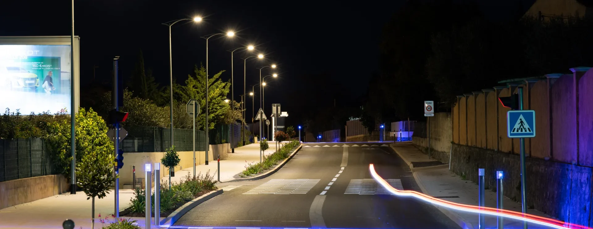 Avenue résidentielle éclairée de nuit par des candélabres LED, avec bornes lumineuses et passage piéton, à La Garde dans le Var