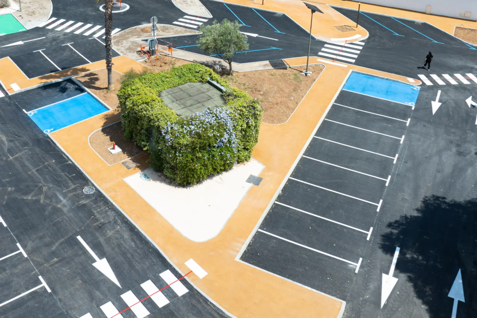 Îlot central végétalisé, places réservées aux personnes à mobilité réduite et mât d’éclairage solaire du parking De Lattre de Tassigny à La Crau (Var)