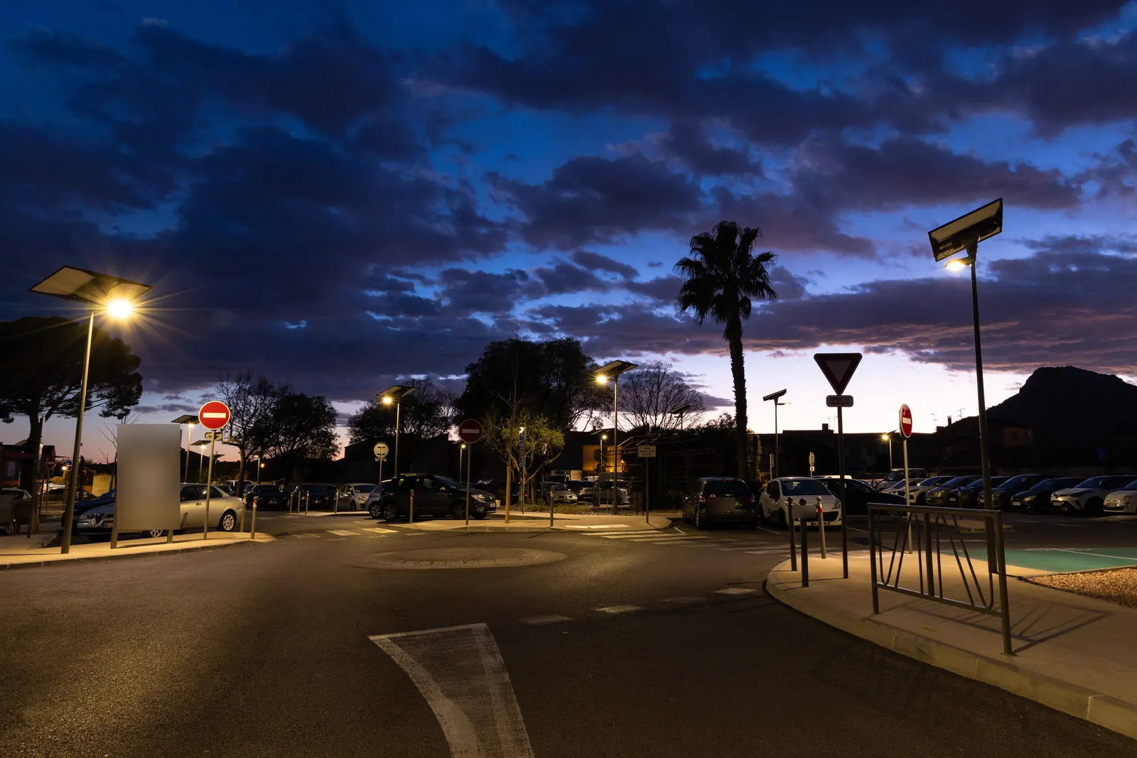 Mâts solaires allumés autour d’un carrefour du parking De Lattre de Tassigny, à La Crau (Var)